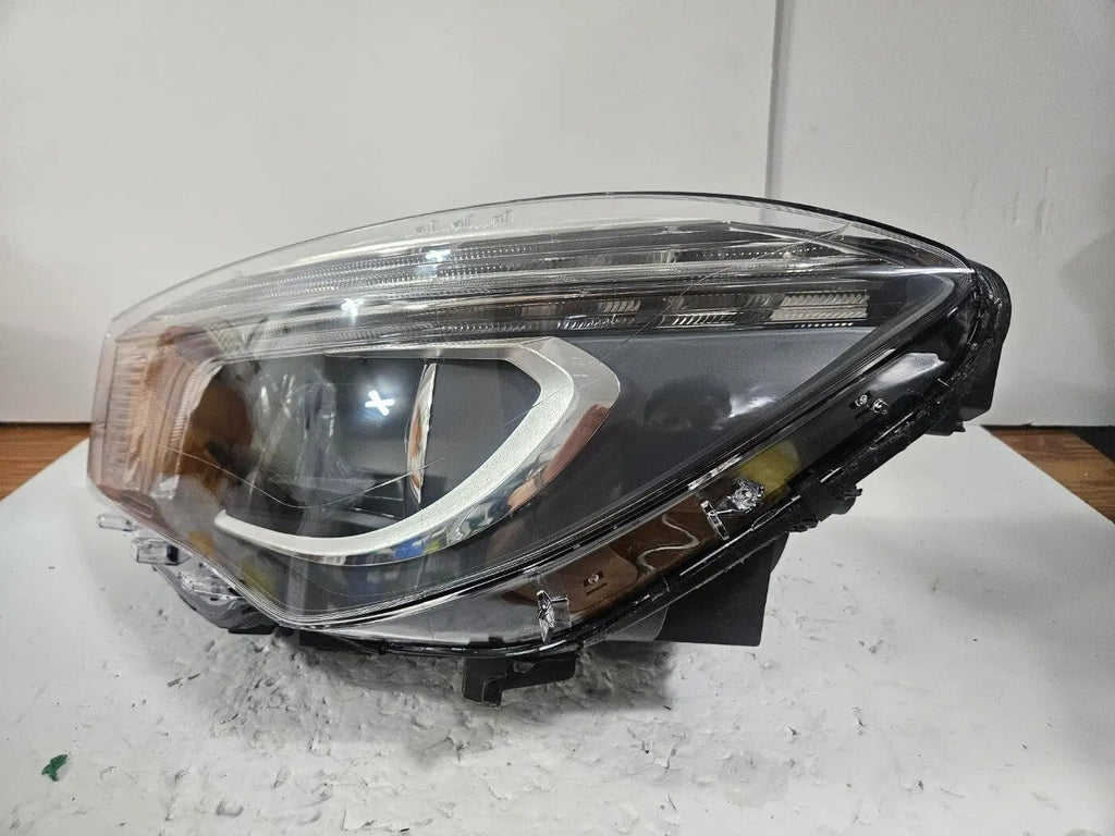 This image shows the left-side Xenon headlight for the Mercedes-Benz CLA Class C117, featuring original OEM quality with part number A1179065100. The headlight is a used but genuine component, designed to perfectly fit the left side of the CLA C117 model. It includes the factory-built Xenon lighting system and showcases the durable construction expected from Mercedes-Benz parts.