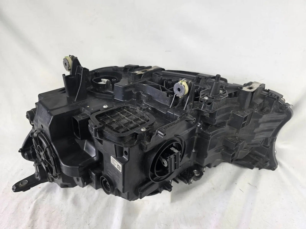 Used genuine BMW Laser headlight for 7 Series models G11 and G12. This right-side OEM headlamp, part number 7465606, features advanced laser lighting technology for superior visibility and performance. The image shows the original BMW right laser headlight in used condition, highlighting the detailed lens design, housing structure, and connector ports — ideal for high-end replacement or repair on compatible 7 Series vehicles.
