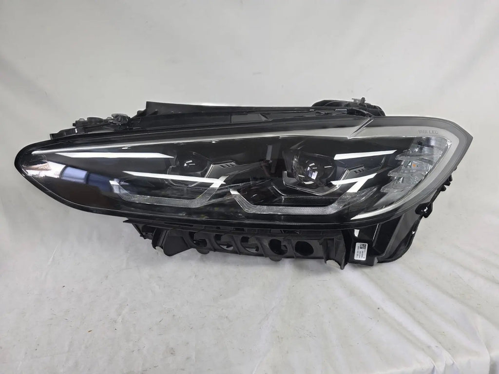 Used genuine BMW LED headlight for 4 Series models including G22, G23, G26, G80, G82, and G83. This left-side OEM headlamp, part number 9851035, is designed to perfectly fit and function in compatible BMW vehicles. The image shows the original BMW LED headlight in used condition with visible connectors, housing, and lens – ideal for replacement or repair of your vehicle’s front lighting system.
