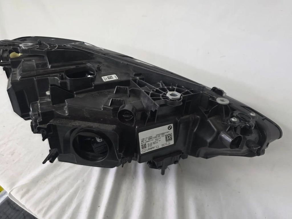 Used genuine BMW LED headlight for 4 Series models including G22, G23, G26, G80, G82, and G83. This left-side OEM headlamp, part number 9851035, is designed to perfectly fit and function in compatible BMW vehicles. The image shows the original BMW LED headlight in used condition with visible connectors, housing, and lens – ideal for replacement or repair of your vehicle’s front lighting system.