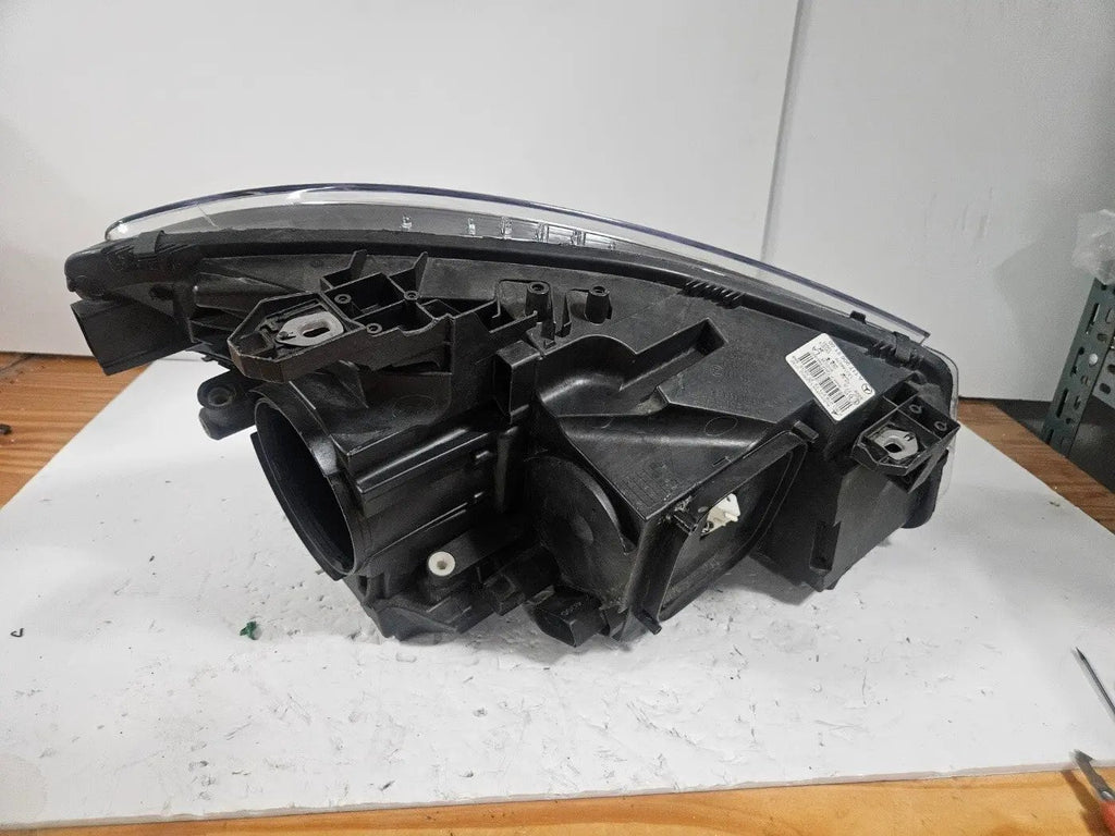This image shows the left-side Xenon headlight for the Mercedes-Benz CLA Class C117, featuring original OEM quality with part number A1179065100. The headlight is a used but genuine component, designed to perfectly fit the left side of the CLA C117 model. It includes the factory-built Xenon lighting system and showcases the durable construction expected from Mercedes-Benz parts.