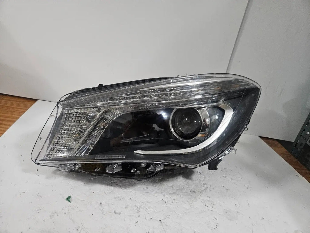 "This image shows the left-side Xenon headlight for the Mercedes-Benz CLA Class C117, featuring original OEM quality with part number A1179065100. The headlight is a used but genuine component, designed to perfectly fit the left side of the CLA C117 model. It includes the factory-built Xenon lighting system and showcases the durable construction expected from Mercedes-Benz parts."