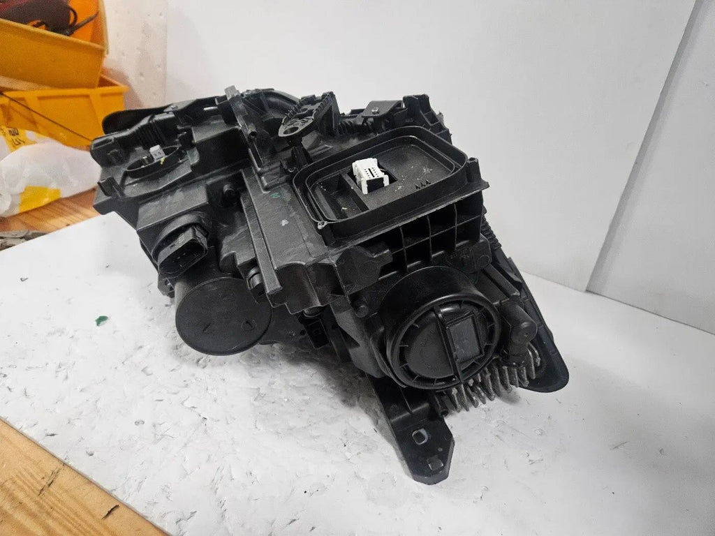 Genuine used Mercedes-Benz Bi-Xenon headlight for GLA-Class model X156. This left-side (LH) OEM headlamp, part number A1569061700, features Bi-Xenon lighting technology for enhanced night visibility and a focused beam pattern. The image shows the original left headlight in used condition, highlighting the lens clarity, projector unit, mounting brackets, and electrical connector — ideal for replacing a damaged headlamp on compatible Mercedes-Benz GLA X156 vehicles.