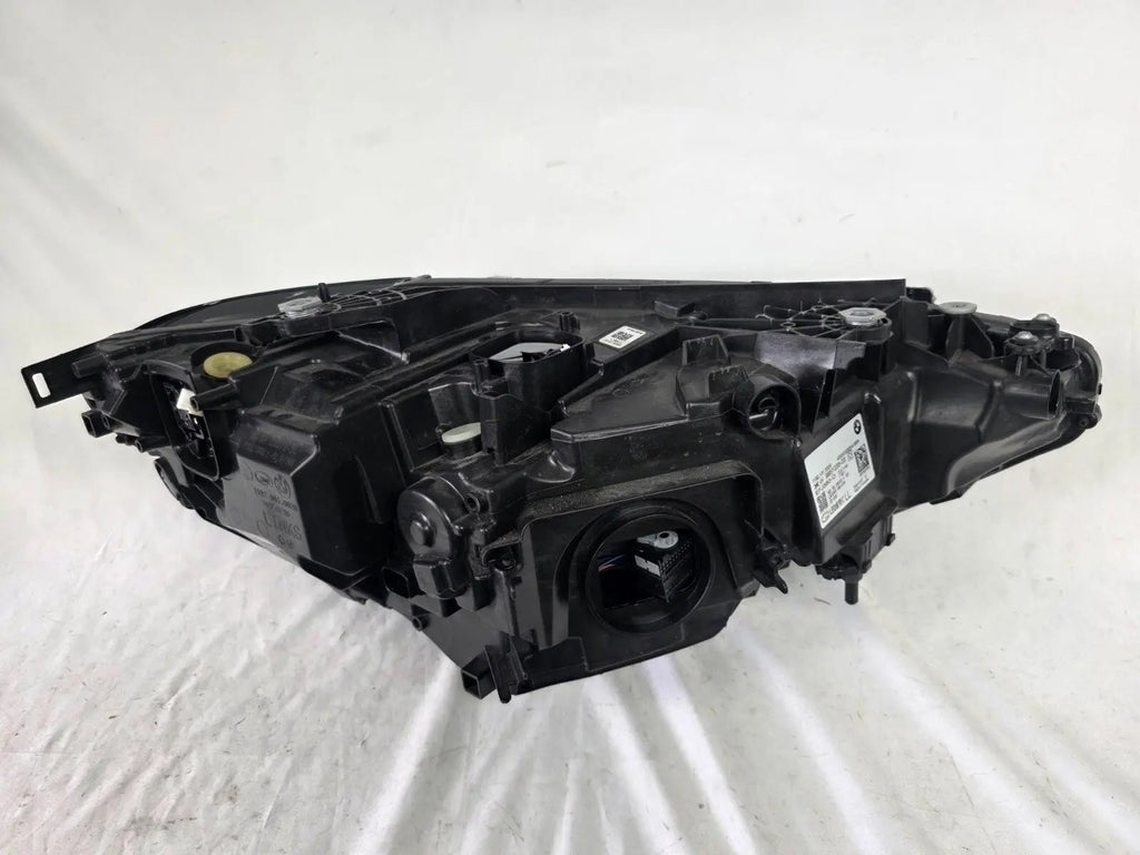 Used genuine BMW LED headlight for 4 Series models including G22, G23, G26, G80, G82, and G83. This left-side OEM headlamp, part number 9851035, is designed to perfectly fit and function in compatible BMW vehicles. The image shows the original BMW LED headlight in used condition with visible connectors, housing, and lens – ideal for replacement or repair of your vehicle’s front lighting system.