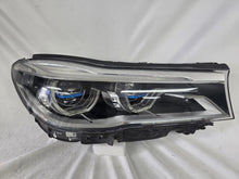 Load image into Gallery viewer, Used genuine BMW Laser headlight for 7 Series models G11 and G12. This right-side OEM headlamp, part number 7465606, features advanced laser lighting technology for superior visibility and performance. The image shows the original BMW right laser headlight in used condition, highlighting the detailed lens design, housing structure, and connector ports — ideal for high-end replacement or repair on compatible 7 Series vehicles.