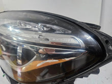 Load image into Gallery viewer, Genuine used Mercedes-Benz Bi-Xenon headlight for GLA-Class model X156. This left-side (LH) OEM headlamp, part number A1569061700, features Bi-Xenon lighting technology for enhanced night visibility and a focused beam pattern. The image shows the original left headlight in used condition, highlighting the lens clarity, projector unit, mounting brackets, and electrical connector — ideal for replacing a damaged headlamp on compatible Mercedes-Benz GLA X156 vehicles.