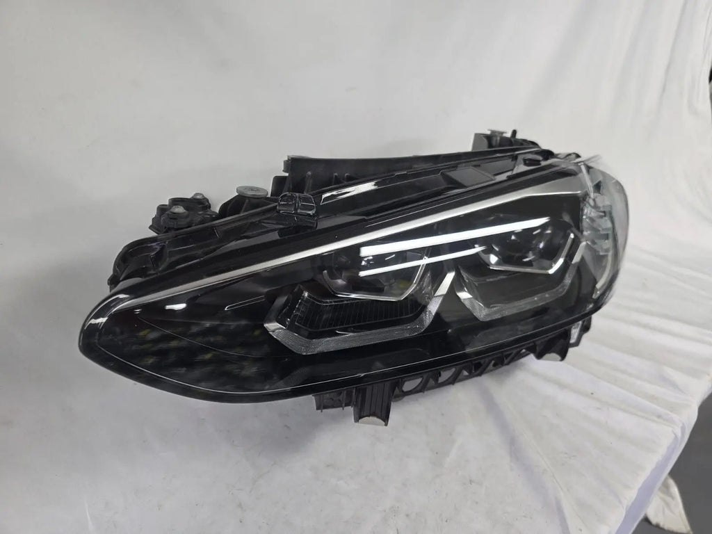 Used genuine BMW LED headlight for 4 Series models including G22, G23, G26, G80, G82, and G83. This left-side OEM headlamp, part number 9851035, is designed to perfectly fit and function in compatible BMW vehicles. The image shows the original BMW LED headlight in used condition with visible connectors, housing, and lens – ideal for replacement or repair of your vehicle’s front lighting system.