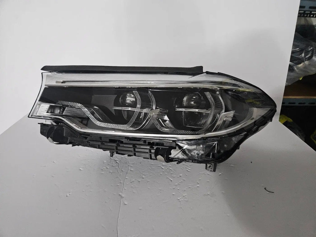 This image shows the left-side Adaptive LED ICON headlight for the BMW 5 Series G30, G31, G38, and F90 LCI models, featuring OEM genuine quality with part number 8499121. This used original headlamp is designed for the facelifted (LCI) versions of these models, offering BMW’s signature Adaptive LED ICON lighting technology for enhanced visibility, precise beam control, and a sleek, modern design.