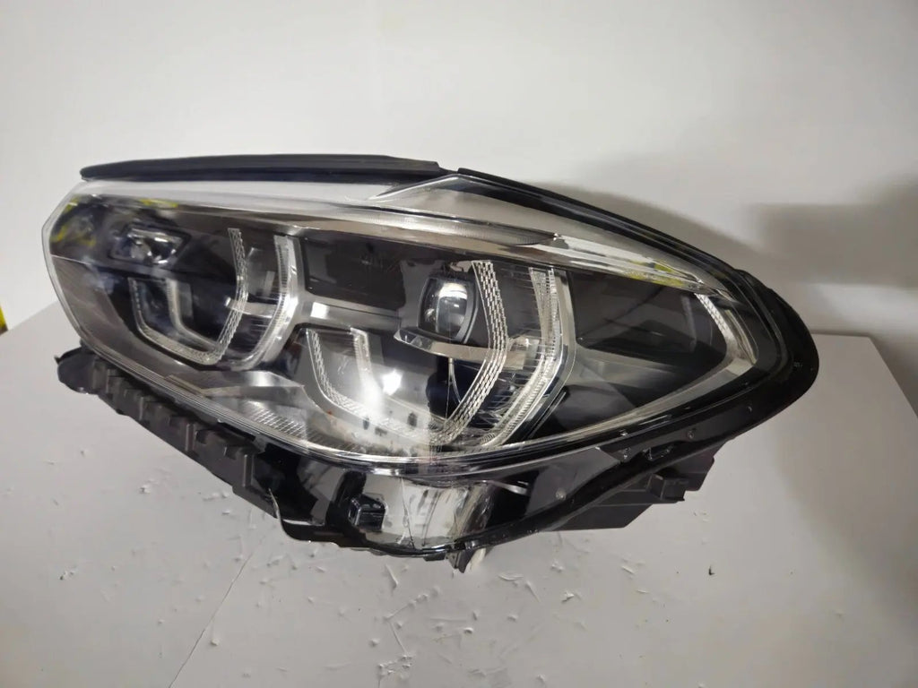 This image shows the left-side ICON Adaptive LED headlight for BMW models iX3 G08, X3 G01, X3 M F97, X4 G02, and X4 M F98, featuring OEM genuine quality with part number 7466119. This used original headlamp is designed to deliver BMW’s signature Adaptive LED lighting with ICON styling, ensuring precise fitment, enhanced visibility, and modern aesthetics for these high-performance models.