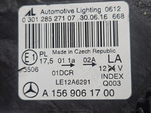 Load image into Gallery viewer, Genuine used Mercedes-Benz Bi-Xenon headlight for GLA-Class model X156. This left-side (LH) OEM headlamp, part number A1569061700, features Bi-Xenon lighting technology for enhanced night visibility and a focused beam pattern. The image shows the original left headlight in used condition, highlighting the lens clarity, projector unit, mounting brackets, and electrical connector — ideal for replacing a damaged headlamp on compatible Mercedes-Benz GLA X156 vehicles.