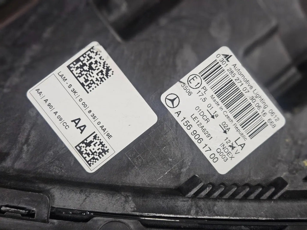 Genuine used Mercedes-Benz Bi-Xenon headlight for GLA-Class model X156. This left-side (LH) OEM headlamp, part number A1569061700, features Bi-Xenon lighting technology for enhanced night visibility and a focused beam pattern. The image shows the original left headlight in used condition, highlighting the lens clarity, projector unit, mounting brackets, and electrical connector — ideal for replacing a damaged headlamp on compatible Mercedes-Benz GLA X156 vehicles.