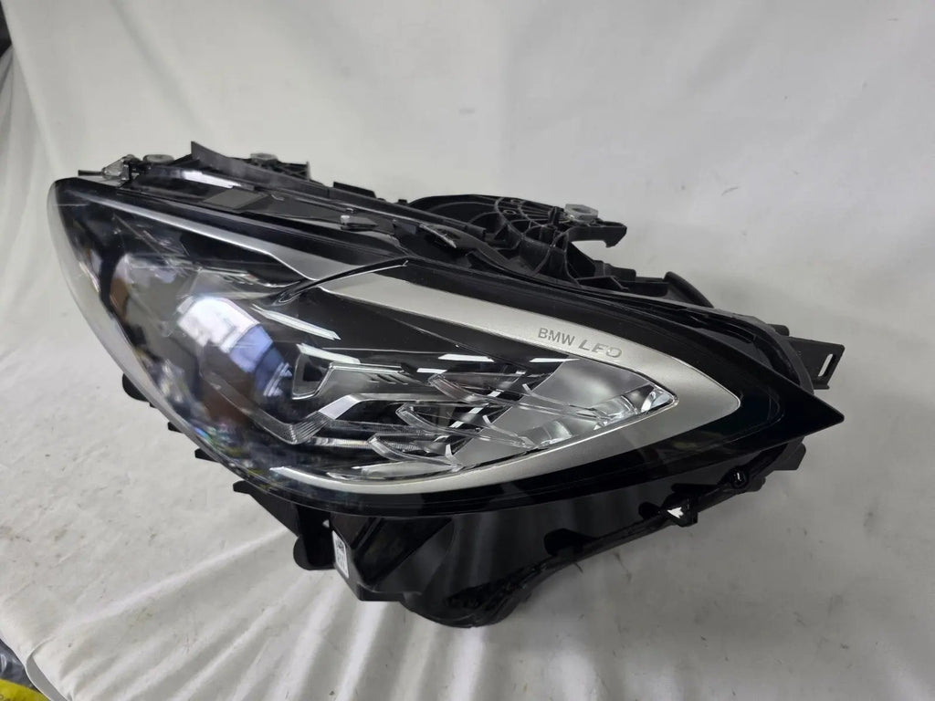 Used genuine BMW LED headlight for 4 Series models including G22, G23, G26, G80, G82, and G83. This left-side OEM headlamp, part number 9851035, is designed to perfectly fit and function in compatible BMW vehicles. The image shows the original BMW LED headlight in used condition with visible connectors, housing, and lens – ideal for replacement or repair of your vehicle’s front lighting system.