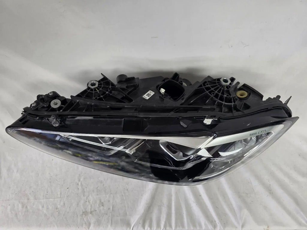 Used genuine BMW LED headlight for 4 Series models including G22, G23, G26, G80, G82, and G83. This left-side OEM headlamp, part number 9851035, is designed to perfectly fit and function in compatible BMW vehicles. The image shows the original BMW LED headlight in used condition with visible connectors, housing, and lens – ideal for replacement or repair of your vehicle’s front lighting system.
