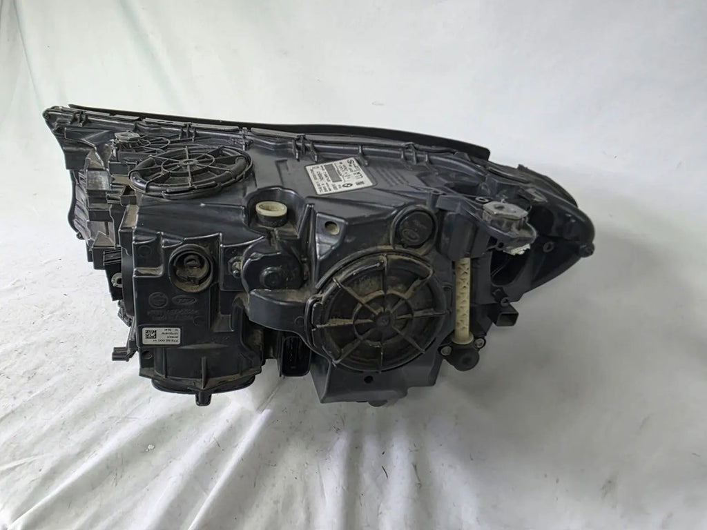 Used genuine BMW Laser headlight for 7 Series models G11 and G12. This right-side OEM headlamp, part number 7465606, features advanced laser lighting technology for superior visibility and performance. The image shows the original BMW right laser headlight in used condition, highlighting the detailed lens design, housing structure, and connector ports — ideal for high-end replacement or repair on compatible 7 Series vehicles.