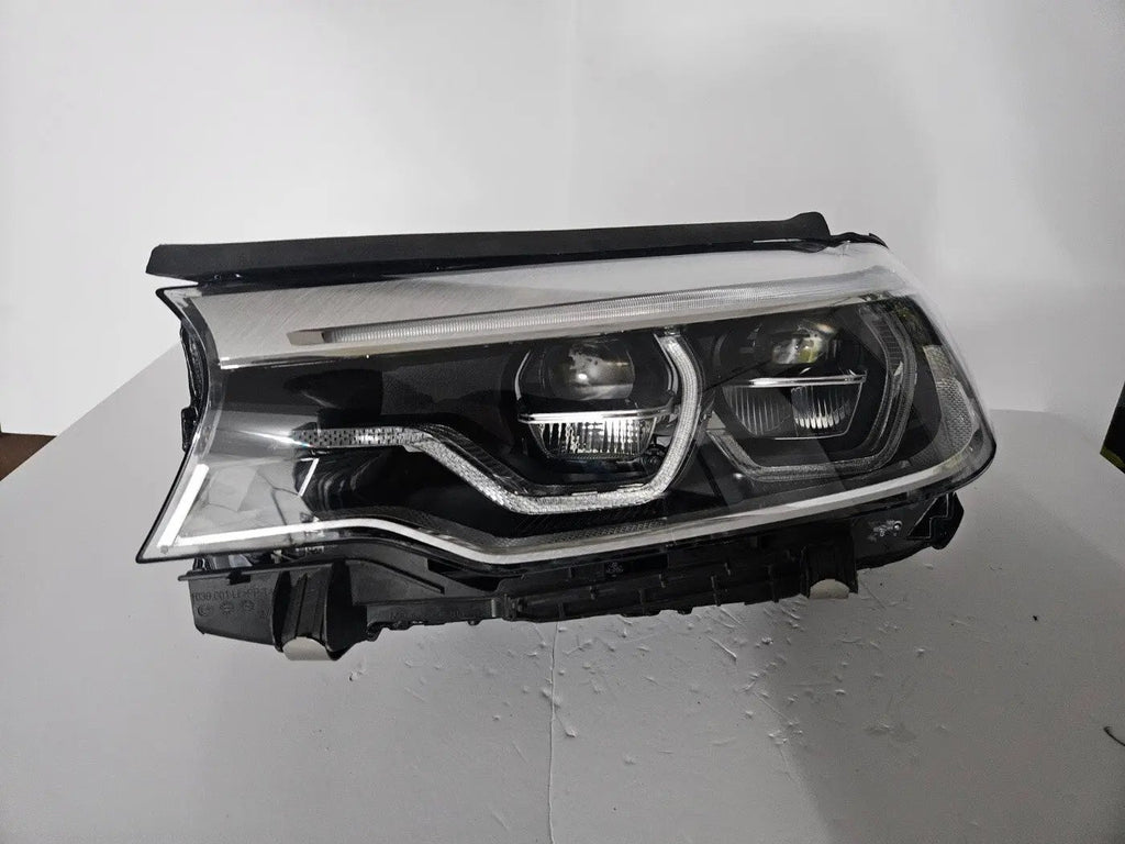 This image shows the left-side Adaptive LED ICON headlight for the BMW 5 Series G30, G31, G38, and F90 LCI models, featuring OEM genuine quality with part number 8499121. This used original headlamp is designed for the facelifted (LCI) versions of these models, offering BMW’s signature Adaptive LED ICON lighting technology for enhanced visibility, precise beam control, and a sleek, modern design.