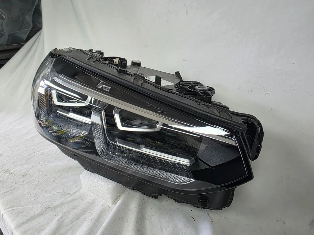 Genuine OEM Adaptive LED headlight for BMW iX3 and compatible models including G08, G01, F97, G02, and F98 with LCI (facelift) updates. This right-side headlamp, part number 5A29204, features adaptive lighting technology for enhanced road illumination and driving safety. The image showcases the original right LED headlight in used condition, clearly showing the lens, housing, and connector points — perfect for replacement on BMW iX3 and related LCI models.