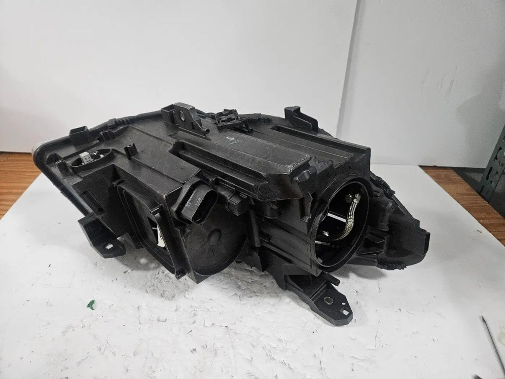 This image shows the left-side Xenon headlight for the Mercedes-Benz CLA Class C117, featuring original OEM quality with part number A1179065100. The headlight is a used but genuine component, designed to perfectly fit the left side of the CLA C117 model. It includes the factory-built Xenon lighting system and showcases the durable construction expected from Mercedes-Benz parts.