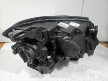 Load image into Gallery viewer, Genuine used Mercedes-Benz Bi-Xenon headlight for GLA-Class model X156. This left-side (LH) OEM headlamp, part number A1569061700, features Bi-Xenon lighting technology for enhanced night visibility and a focused beam pattern. The image shows the original left headlight in used condition, highlighting the lens clarity, projector unit, mounting brackets, and electrical connector — ideal for replacing a damaged headlamp on compatible Mercedes-Benz GLA X156 vehicles.