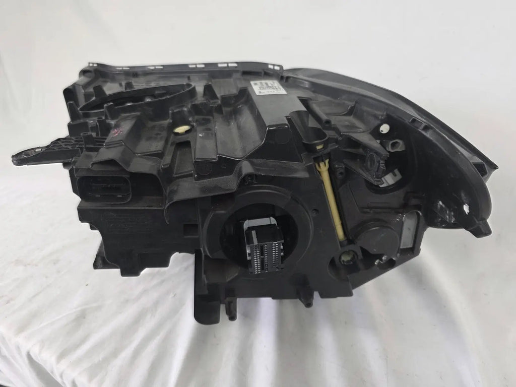 Used genuine BMW Adaptive LED headlight for X1 F48 LCI (facelift) model. This right-side OEM headlamp, part number 5A01178, is equipped with adaptive lighting technology for improved night visibility and cornering performance. The image displays the original right Adaptive LED headlight in used condition, showing the clear lens, mounting brackets, and electrical connectors — an ideal OEM replacement for BMW X1 F48 LCI vehicles.