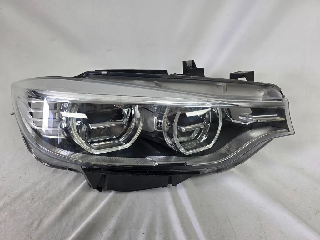 Genuine used BMW Adaptive LED headlight for 4 Series models F32, F33, F36, F80 LCI, F82, and F83. This right-side OEM headlamp, part number 7377842, is designed with adaptive lighting technology for improved visibility and performance. The image highlights the complete original headlight unit in used condition, including the clear lens, mounting points, and electrical connectors — ideal for replacement on compatible BMW models.