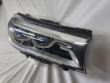 Load image into Gallery viewer, Used genuine BMW Laser headlight for 7 Series models G11 and G12. This right-side OEM headlamp, part number 7465606, features advanced laser lighting technology for superior visibility and performance. The image shows the original BMW right laser headlight in used condition, highlighting the detailed lens design, housing structure, and connector ports — ideal for high-end replacement or repair on compatible 7 Series vehicles.
