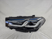 Load image into Gallery viewer, Genuine OEM BMW Laser headlight for 5 Series models G30, G31, and F90 LCI (facelift). This left-side headlamp, part number 5A388D5, is equipped with advanced laser lighting technology for superior visibility and precision on the road. The image displays the original left laser headlight in used condition, clearly showing the lens structure, cooling fins, mounting points, and connector ports — ideal for OEM replacement on compatible BMW 5 Series LCI vehicles.

