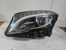 Load image into Gallery viewer, Genuine used Mercedes-Benz Bi-Xenon headlight for GLA-Class model X156. This left-side (LH) OEM headlamp, part number A1569061700, features Bi-Xenon lighting technology for enhanced night visibility and a focused beam pattern. The image shows the original left headlight in used condition, highlighting the lens clarity, projector unit, mounting brackets, and electrical connector — ideal for replacing a damaged headlamp on compatible Mercedes-Benz GLA X156 vehicles.

