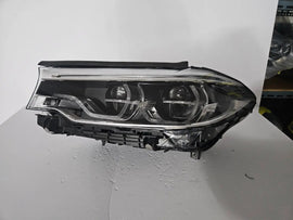 This image shows the left-side Adaptive LED ICON headlight for the BMW 5 Series G30, G31, G38, and F90 LCI models, featuring OEM genuine quality with part number 8499121. This used original headlamp is designed for the facelifted (LCI) versions of these models, offering BMW’s signature Adaptive LED ICON lighting technology for enhanced visibility, precise beam control, and a sleek, modern design.