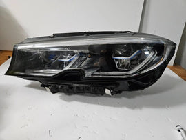 Genuine used BMW Laser headlight for 3 Series models G20 and G21. This left-side OEM headlamp, part number 9481707, features high-performance laser lighting technology for superior road visibility and driving precision. The image showcases the original left laser headlight in used condition, clearly showing the lens structure, housing, and connector ports — ideal for replacing a damaged headlamp on compatible BMW 3 Series vehicles.

