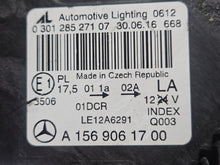Load image into Gallery viewer, Genuine used Mercedes-Benz Bi-Xenon headlight for GLA-Class model X156. This left-side (LH) OEM headlamp, part number A1569061700, features Bi-Xenon lighting technology for enhanced night visibility and a focused beam pattern. The image shows the original left headlight in used condition, highlighting the lens clarity, projector unit, mounting brackets, and electrical connector — ideal for replacing a damaged headlamp on compatible Mercedes-Benz GLA X156 vehicles.