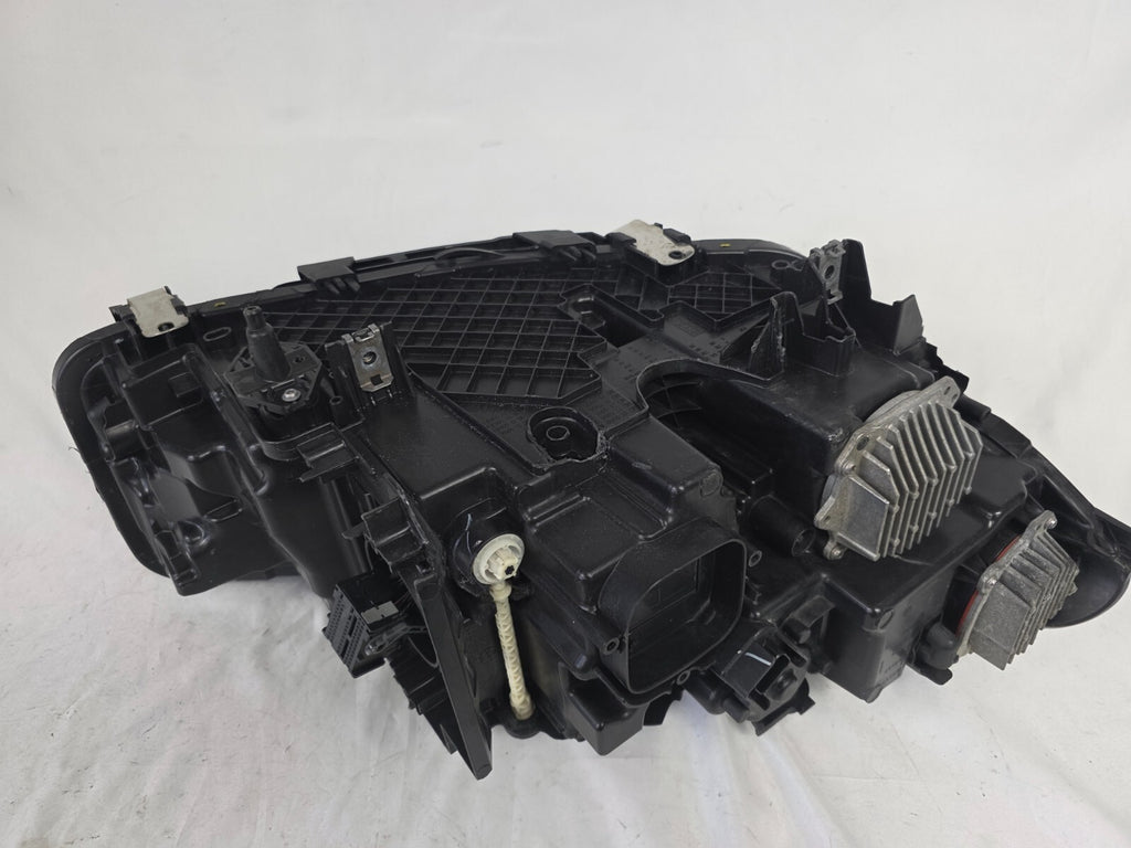 Genuine OEM BMW Laser headlight for 5 Series models G30, G31, and F90 LCI (facelift). This left-side headlamp, part number 5A388D5, is equipped with advanced laser lighting technology for superior visibility and precision on the road. The image displays the original left laser headlight in used condition, clearly showing the lens structure, cooling fins, mounting points, and connector ports — ideal for OEM replacement on compatible BMW 5 Series LCI vehicles.

