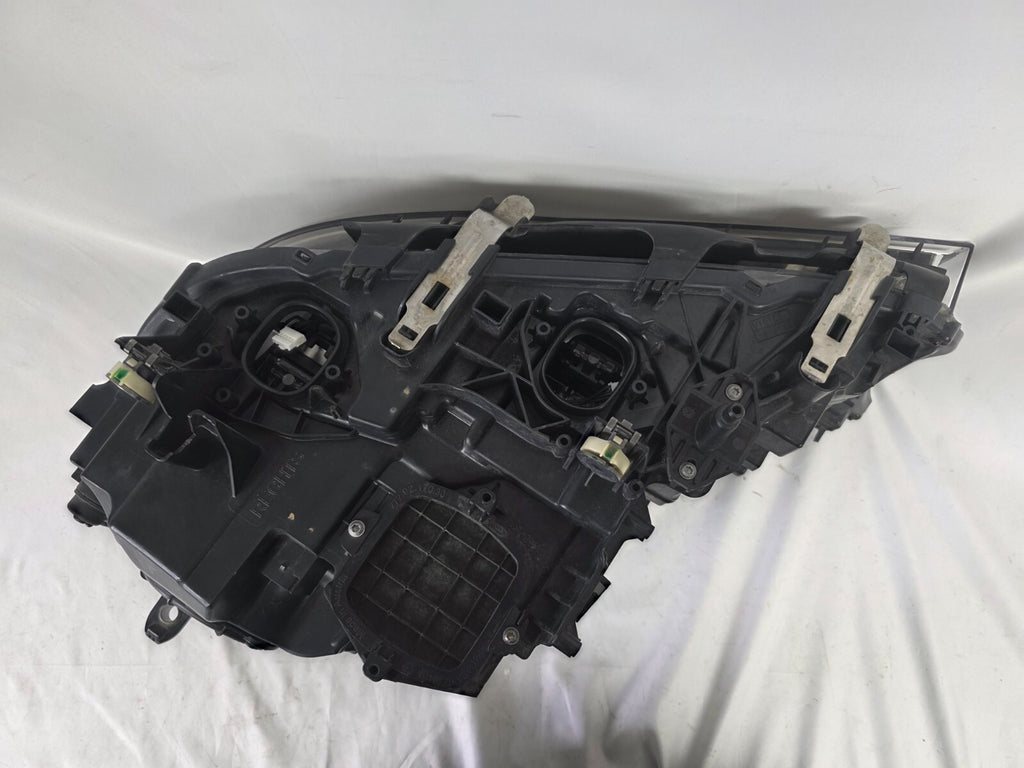 Used genuine BMW Laser headlight for 7 Series models G11 and G12. This right-side OEM headlamp, part number 7465606, features advanced laser lighting technology for superior visibility and performance. The image shows the original BMW right laser headlight in used condition, highlighting the detailed lens design, housing structure, and connector ports — ideal for high-end replacement or repair on compatible 7 Series vehicles.

