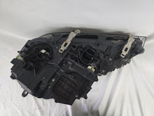 Load image into Gallery viewer, Used genuine BMW Laser headlight for 7 Series models G11 and G12. This right-side OEM headlamp, part number 7465606, features advanced laser lighting technology for superior visibility and performance. The image shows the original BMW right laser headlight in used condition, highlighting the detailed lens design, housing structure, and connector ports — ideal for high-end replacement or repair on compatible 7 Series vehicles.

