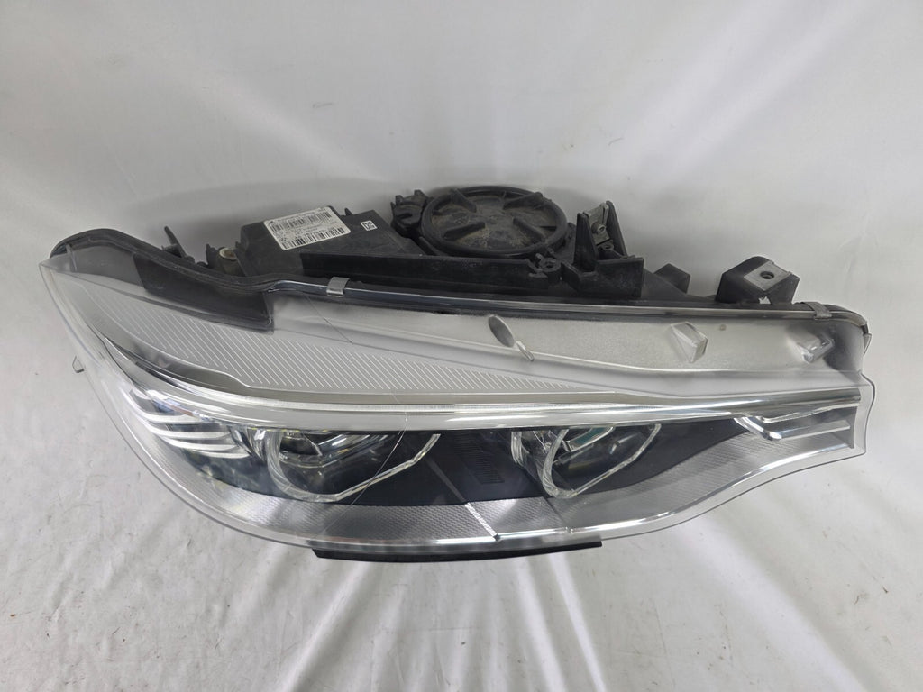 Genuine used BMW Adaptive LED headlight for 4 Series models F32, F33, F36, F80 LCI, F82, and F83. This right-side OEM headlamp, part number 7377842, is designed with adaptive lighting technology for improved visibility and performance. The image highlights the complete original headlight unit in used condition, including the clear lens, mounting points, and electrical connectors — ideal for replacement on compatible BMW models.