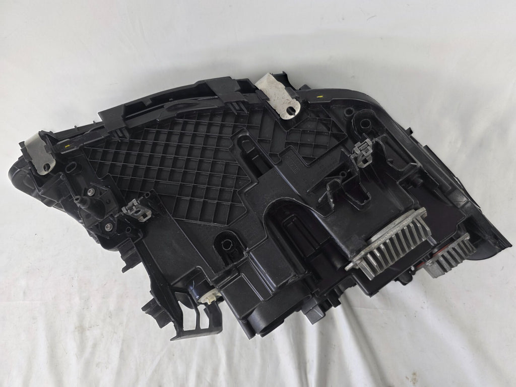Genuine OEM BMW Laser headlight for 5 Series models G30, G31, and F90 LCI (facelift). This left-side headlamp, part number 5A388D5, is equipped with advanced laser lighting technology for superior visibility and precision on the road. The image displays the original left laser headlight in used condition, clearly showing the lens structure, cooling fins, mounting points, and connector ports — ideal for OEM replacement on compatible BMW 5 Series LCI vehicles.


