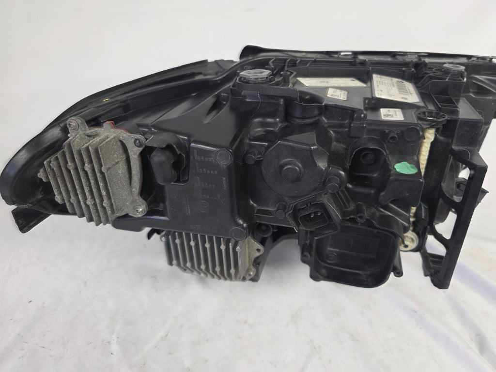 Genuine OEM BMW Laser headlight for 5 Series models G30, G31, and F90 LCI (facelift). This left-side headlamp, part number 5A388D5, is equipped with advanced laser lighting technology for superior visibility and precision on the road. The image displays the original left laser headlight in used condition, clearly showing the lens structure, cooling fins, mounting points, and connector ports — ideal for OEM replacement on compatible BMW 5 Series LCI vehicles.

