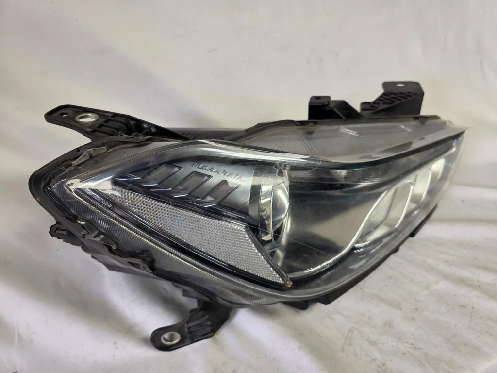 This image shows the right-side Xenon headlight for the Maserati Ghibli models from 2014 to 2017, featuring OEM genuine quality with part number 00670004658. This used original headlamp is designed for perfect fitment, delivering powerful Xenon lighting and the signature sleek styling expected from Maserati’s luxury performance vehicles