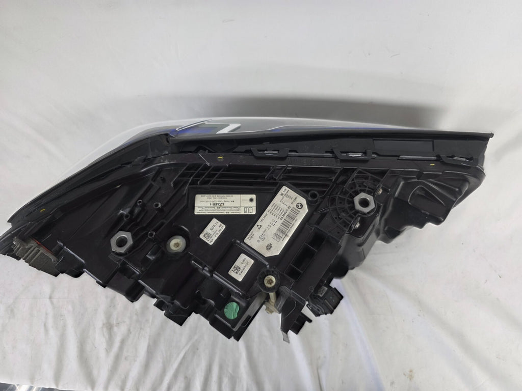 Genuine OEM BMW Laser headlight for 5 Series models G30, G31, and F90 LCI (facelift). This left-side headlamp, part number 5A388D5, is equipped with advanced laser lighting technology for superior visibility and precision on the road. The image displays the original left laser headlight in used condition, clearly showing the lens structure, cooling fins, mounting points, and connector ports — ideal for OEM replacement on compatible BMW 5 Series LCI vehicles.

